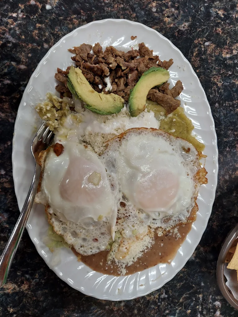 Breakfast plate with eggs, beans, meat and avocado